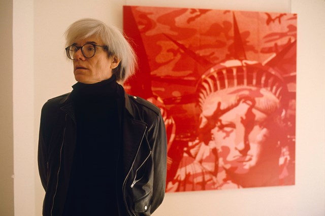 Andy Warhol diante de uma pintura de sua autoria, em 1970