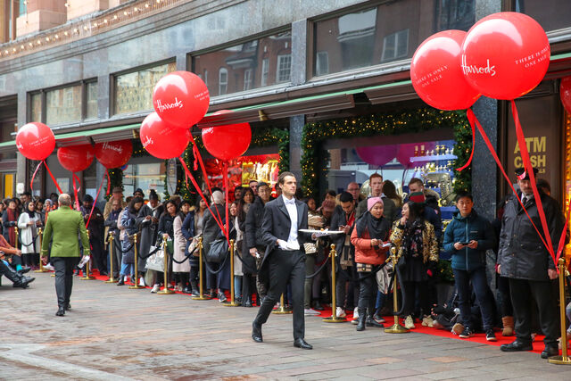 A fila no exterior do Harrods para as promoções do Boxing Day, a 26 de dezembro de 2018. Um mordomo serve bebidas quentes aos clientes na fila