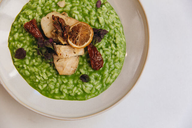 Corvina com limão confit e tomate seco, acompanhada de um delicioso risotto verde, temperado com ervas aromáticas