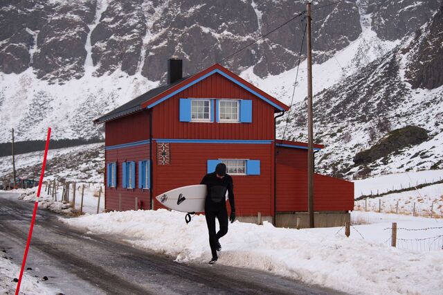 Um surfista na Noruega deixa a praia cheia de neve