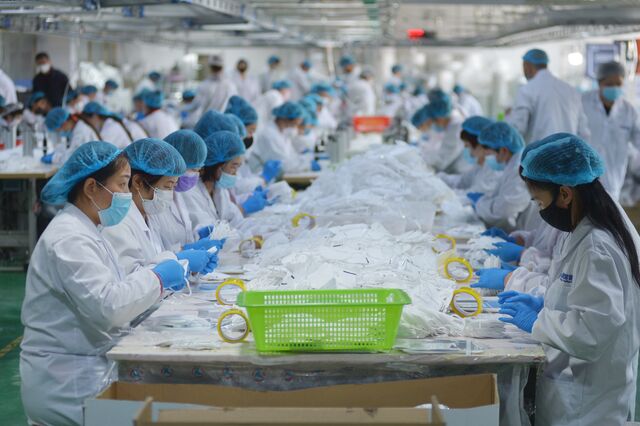 Trabalhadores fazem máscaras numa empresa em Qingdao, leste da China, em 2020