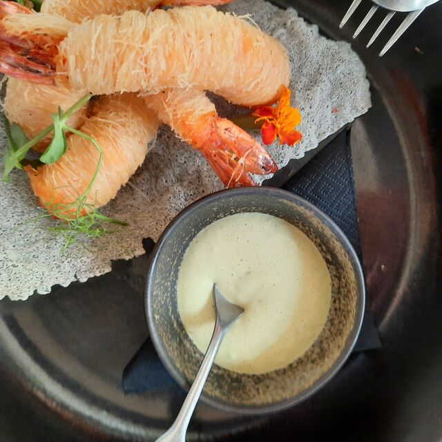"Camarão Kataifi (envolto em massa Kataifi), temperado com ervas aromáticas locais e acompanhado por uma deliciosa maionese de manjericão."