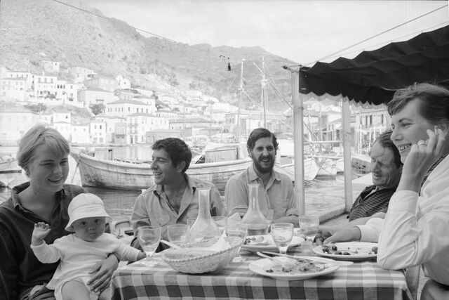 Hydra, Grécia, 1960: Marianne Ihlen segura o filho Axel Jensen Jr ao colo, num almoço com Cohen e um casal amigo