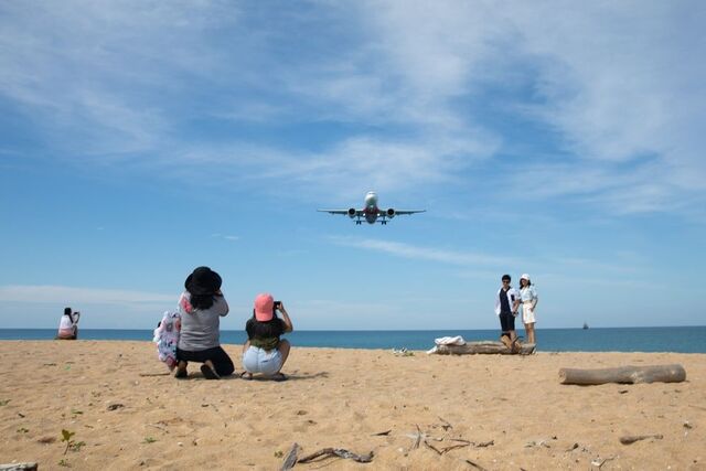 Um avião a aproximar-se do Aeroporto Internacional de Pucket voa por cima de uma praia quase vazia, a 19 de dezembro