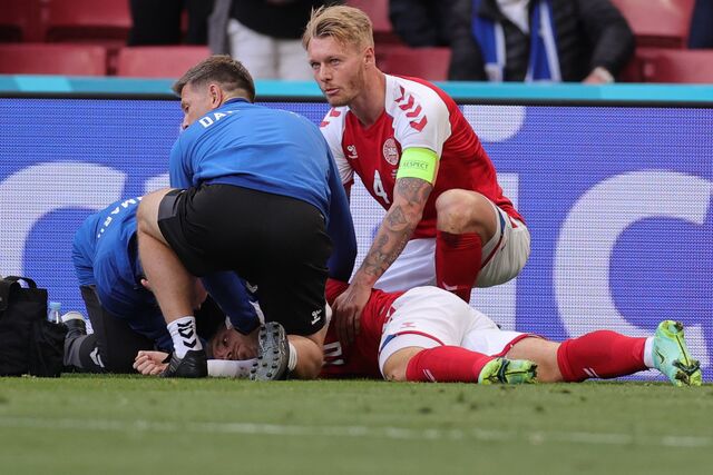 Christian Eriksen acompanhado por um paramédico durante o jogo da UEFA EURO 2020