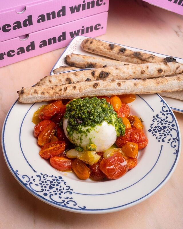 Burrata acompanha com tomates confitados e pesto de pistácio.