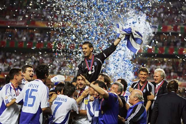 Membros da equipa grega a seguram a taça e festejam, a 4 de julho de 2004, no estádio da Luz, em Lisboa, na final. A Grécia venceu por 1-0. 