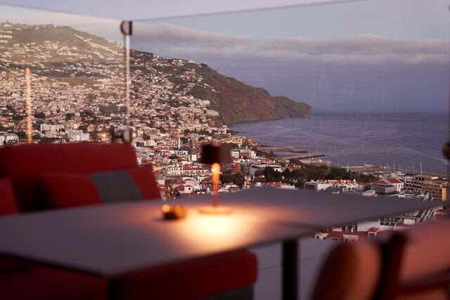 Por mais que tentemos escapar-lhe, voltando as costas e a nuca à magnífica vista sobre a baixa do Funchal, este sol de vigor praticamente bélico ataca-nos por todos os lados.
