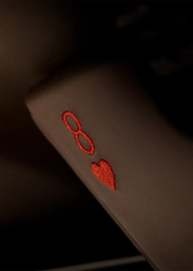 Outro detalhe intrigante é o oito de copas bordado na pala de sol, um elemento que evoca a cena de Miami em Goldfinger, onde Bond e Jill Masterson trocam olhares cúmplices enquanto monitoram um jogo de cartas.