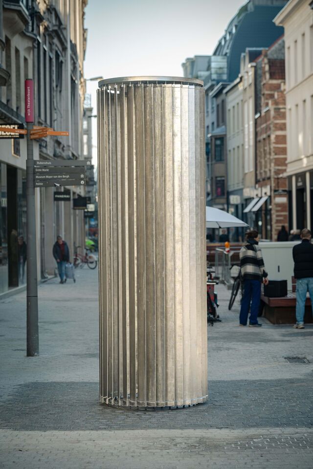 A estrutura circular e o acabamento refletor criam uma peça envolvente, que se integra no ambiente urbano de forma instigante.