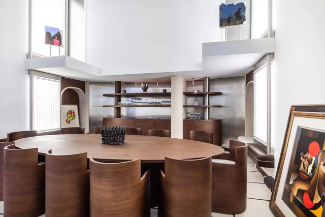 Numa paleta mais quente, a sala e adega relacionam-se com a área de entrada pelas formas ovais e mobília imponente.
