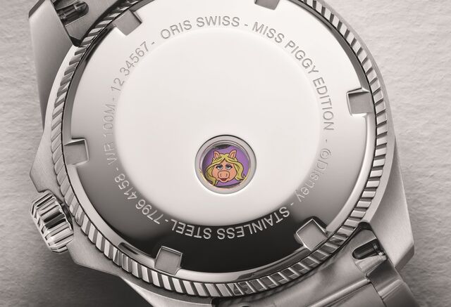A Miss Piggy está estampada no rotor e vai aparecendo numa pequena janela traseira, à medida que esta vai girando