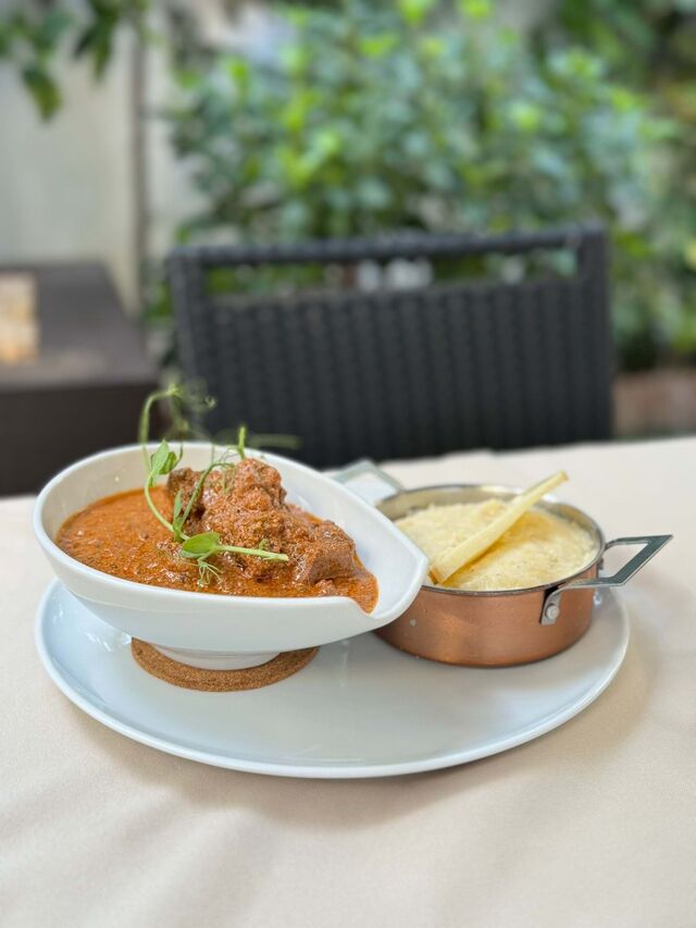 O iakhne é um ensopado de novilho com tomate, nozes e mistura de especiarias georgianas, servido com gomi, uma espécie de creme de milho cozido com queijo