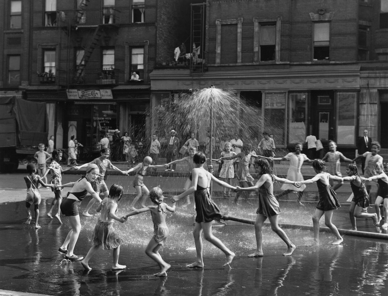 Crianças brincam na água numa rua, em Lisboa, anos 70/80